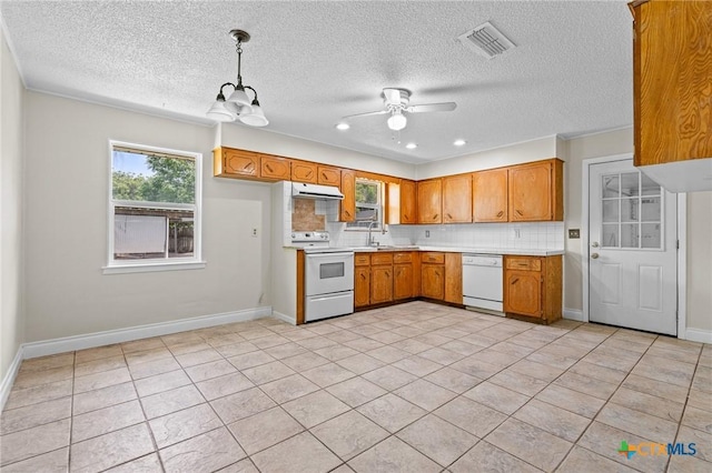 1609 S Ann Blvd, Harker Heights, TX 76548 - kitchen with white appliances, light countertops, exhaust hood, tasteful backsplash, and brown cabinets