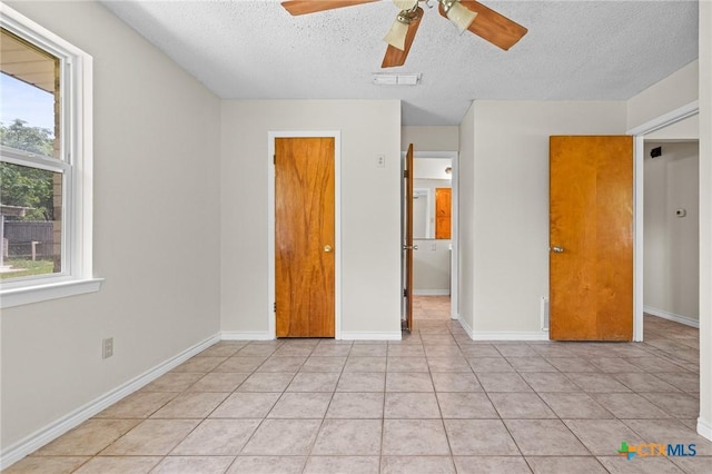 1609 S Ann Blvd, Harker Heights, TX 76548 - unfurnished bedroom featuring a textured ceiling, light tile patterned floors, a ceiling fan, and baseboards