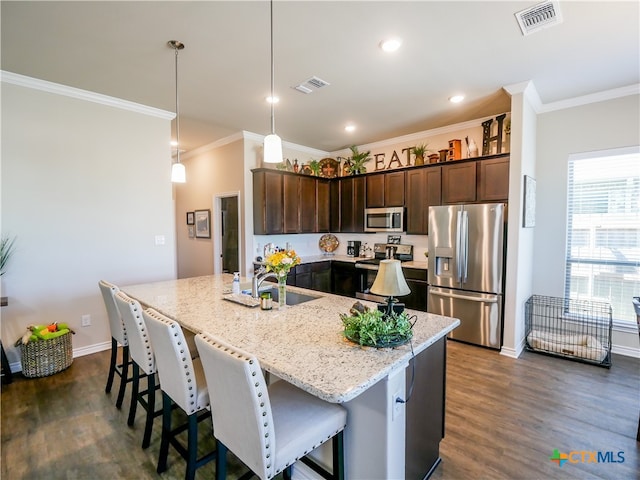 kitchen with stainless steel appliances, dark wood-type flooring, hanging light fixtures, sink, and ornamental molding