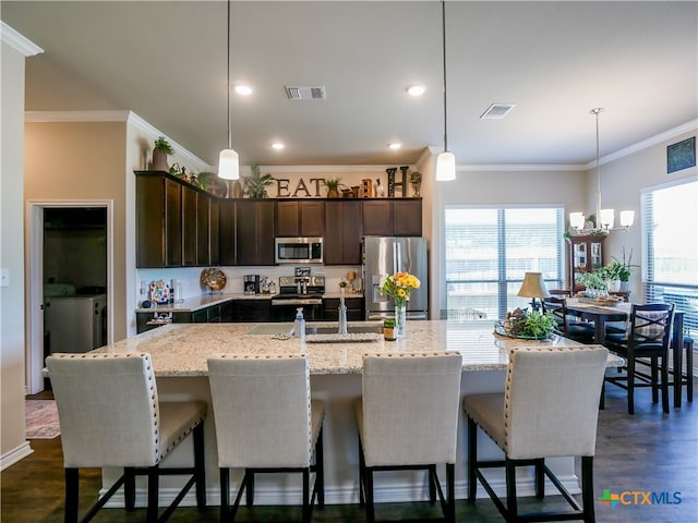 kitchen featuring dark hardwood / wood-style flooring, a wealth of natural light, ornamental molding, and stainless steel appliances