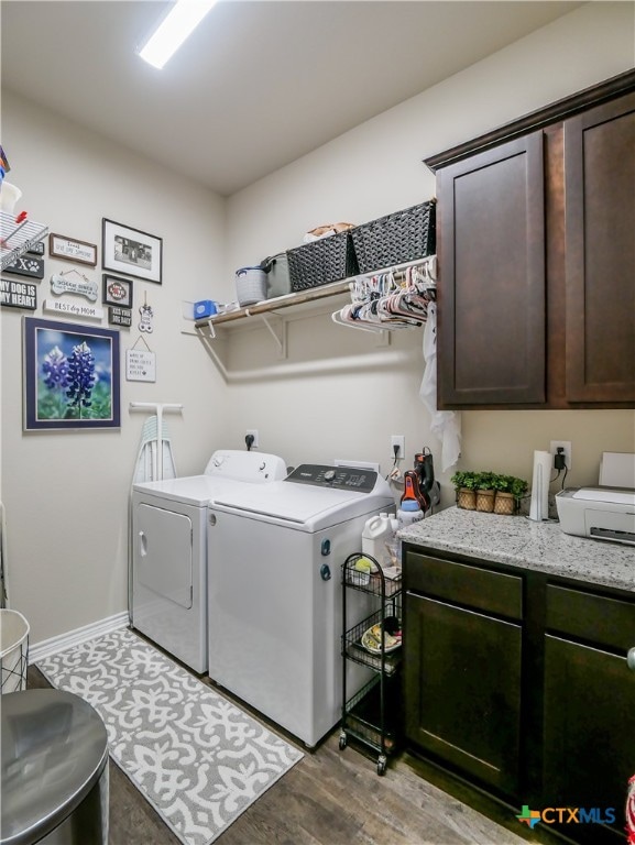 laundry room featuring light wood-type flooring, cabinets, and washing machine and clothes dryer