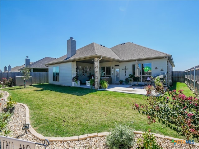 rear view of house with a patio area and a lawn