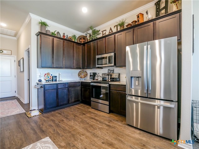 kitchen with dark brown cabinetry, light hardwood / wood-style flooring, crown molding, light stone countertops, and appliances with stainless steel finishes