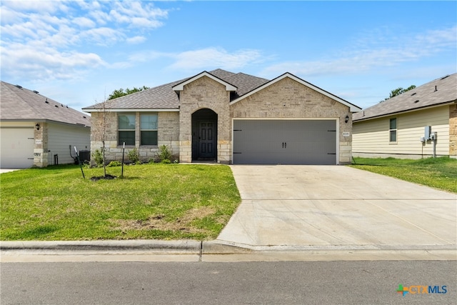 view of front of property featuring a garage, a front lawn, and central AC