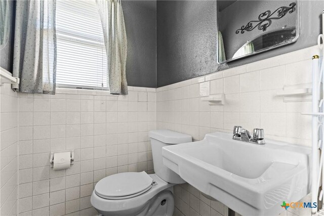 1400 Barbara Ln, Killeen, TX 76549 - bathroom featuring toilet, tile walls, and a sink