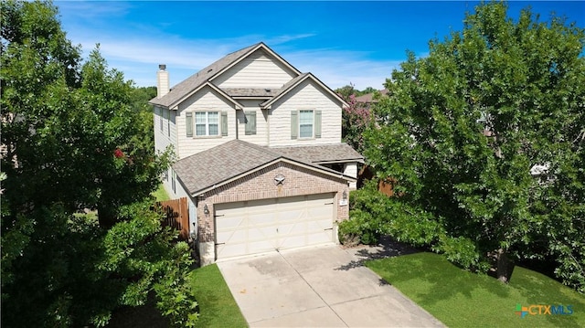 180 Beech Dr, Kyle, TX 78640 - traditional home with concrete driveway, a chimney, a garage, brick siding, and a shingled roof