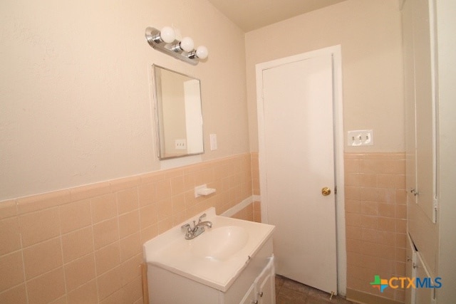 bathroom with vanity and tile walls