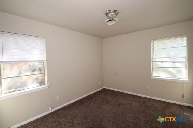 empty room featuring dark colored carpet