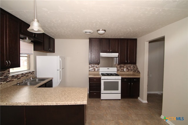 kitchen with tasteful backsplash, sink, decorative light fixtures, and white appliances