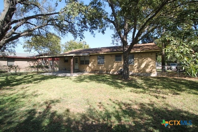 rear view of house featuring a yard and a patio