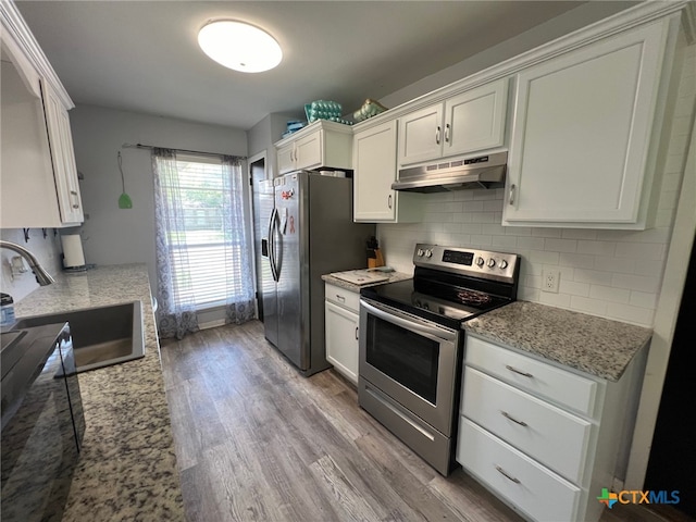 kitchen with sink, appliances with stainless steel finishes, light stone countertops, white cabinets, and light wood-type flooring