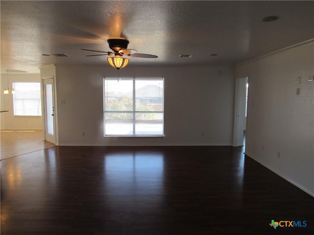 spare room with a textured ceiling, ceiling fan, and dark hardwood / wood-style floors