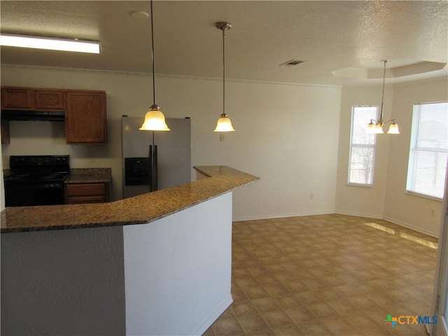 kitchen with decorative light fixtures, a raised ceiling, stainless steel refrigerator with ice dispenser, black / electric stove, and dark stone counters