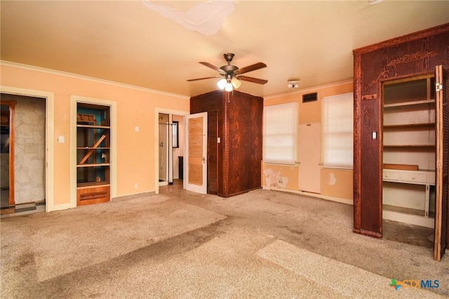 unfurnished living room with crown molding, carpet floors, and ceiling fan