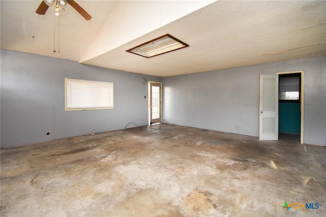 spare room with concrete flooring, lofted ceiling, and ceiling fan