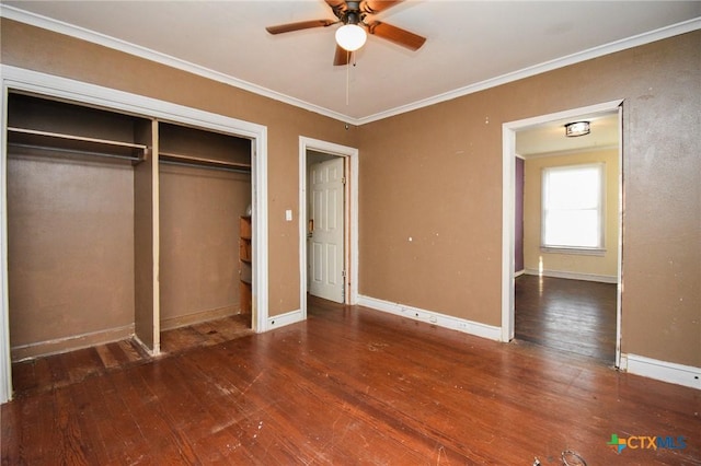 unfurnished bedroom featuring dark wood-type flooring, ornamental molding, and a closet