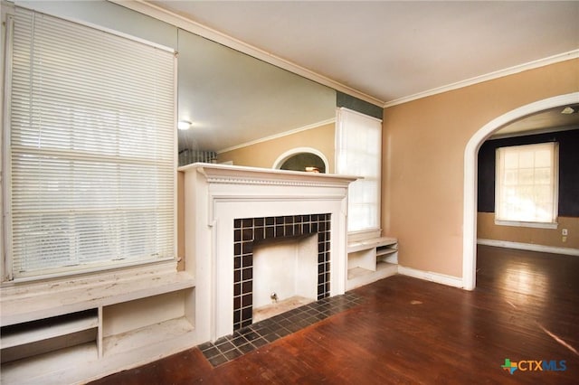 unfurnished living room with crown molding, dark hardwood / wood-style flooring, and a tiled fireplace