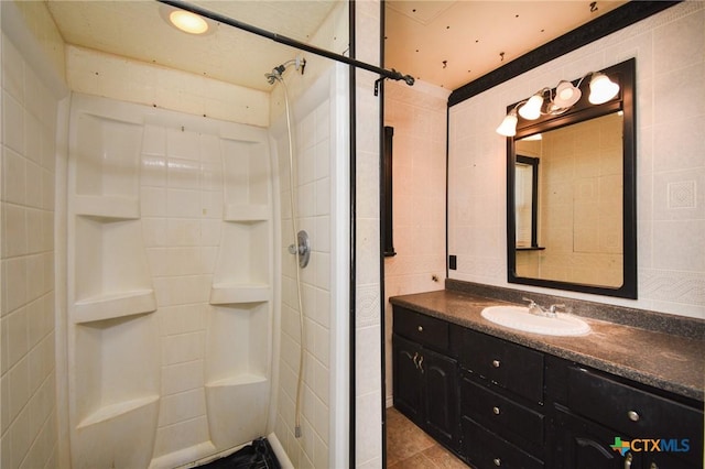 bathroom featuring a shower, tile walls, vanity, and tile patterned floors