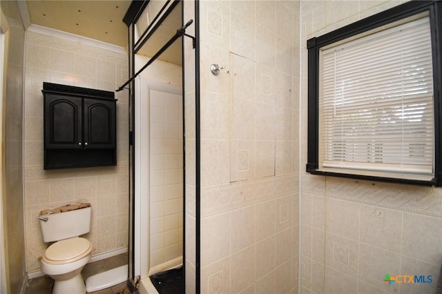 bathroom featuring tile walls and toilet