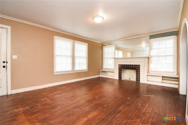 unfurnished living room featuring a tile fireplace, ornamental molding, and wood-type flooring