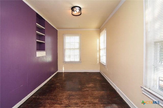 hall with built in shelves, ornamental molding, and hardwood / wood-style floors