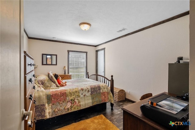 bedroom with visible vents, crown molding, and wood finished floors