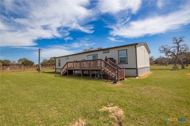 rear view of property featuring stairs, a lawn, fence, and a wooden deck