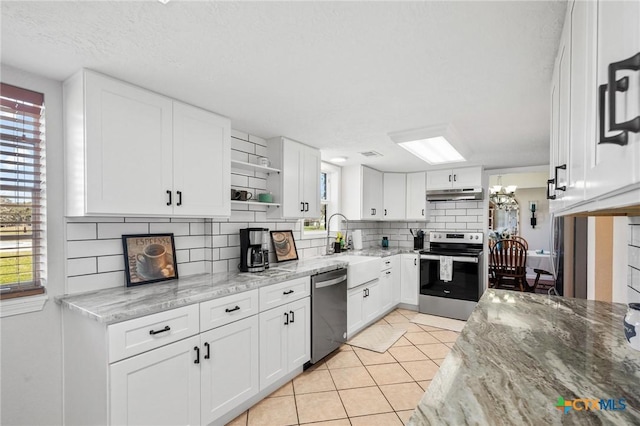 kitchen with stainless steel appliances, under cabinet range hood, white cabinetry, backsplash, and light tile patterned flooring