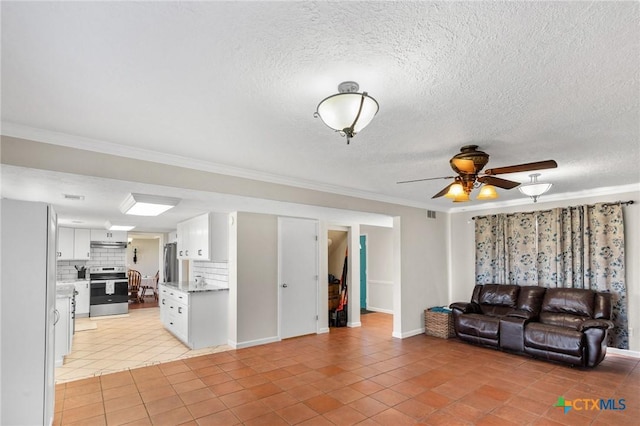 living room featuring ceiling fan, ornamental molding, a textured ceiling, and light tile patterned flooring