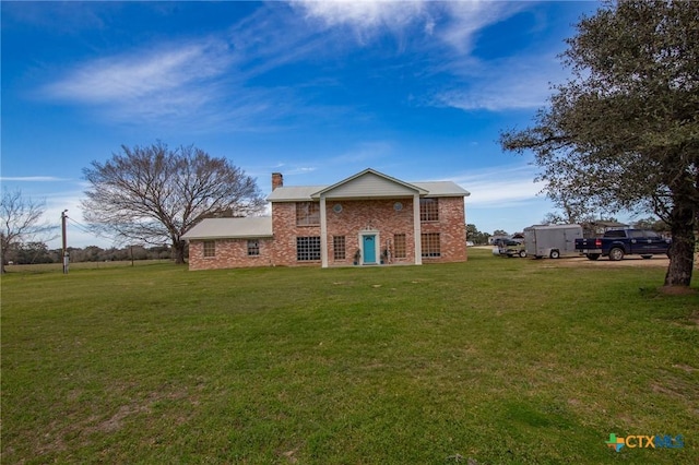 view of front facade with a front yard and a chimney