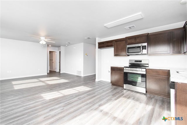 kitchen featuring dark brown cabinetry, visible vents, baseboards, appliances with stainless steel finishes, and light wood-style floors