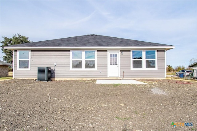 rear view of property with central AC and roof with shingles