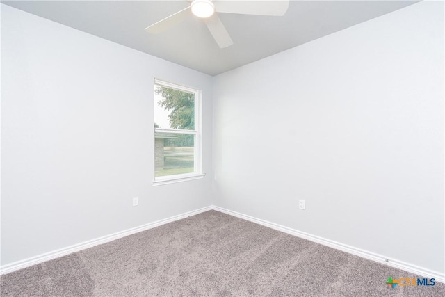 carpeted empty room with a ceiling fan and baseboards