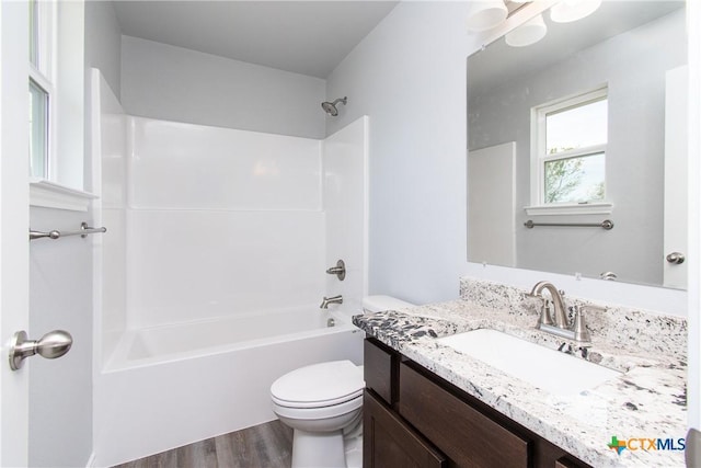 bathroom featuring washtub / shower combination, vanity, wood finished floors, and toilet