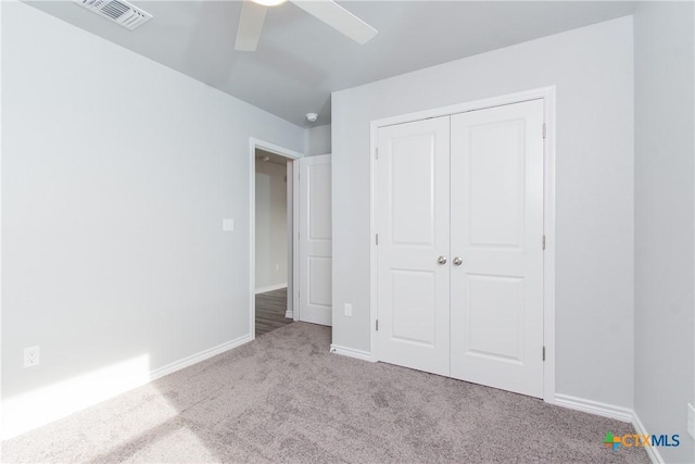 unfurnished bedroom with carpet, a closet, visible vents, and baseboards