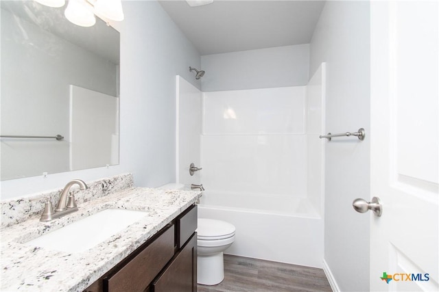 bathroom with  shower combination, vanity, toilet, and wood finished floors