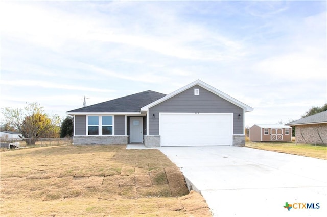 ranch-style house featuring an attached garage, fence, stone siding, driveway, and a front lawn