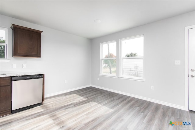 unfurnished dining area with light wood finished floors and baseboards