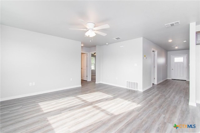 spare room featuring light wood finished floors, baseboards, and visible vents