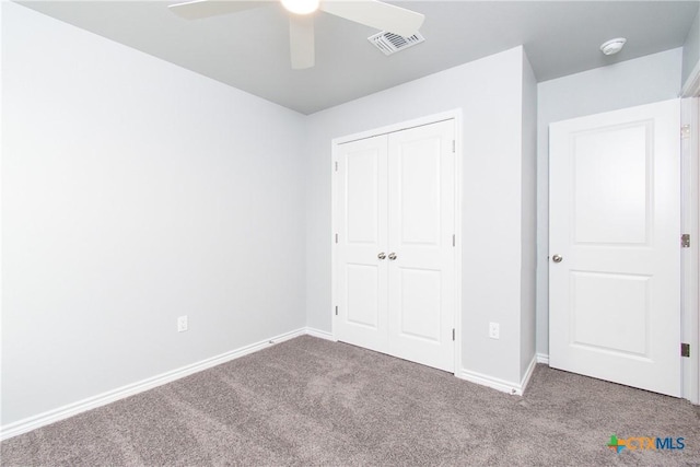 unfurnished bedroom with baseboards, carpet, visible vents, and a closet