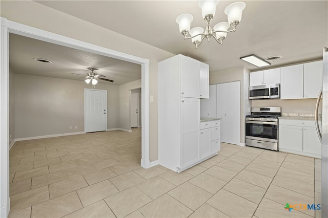 kitchen with decorative light fixtures, stainless steel appliances, visible vents, white cabinetry, and ceiling fan with notable chandelier