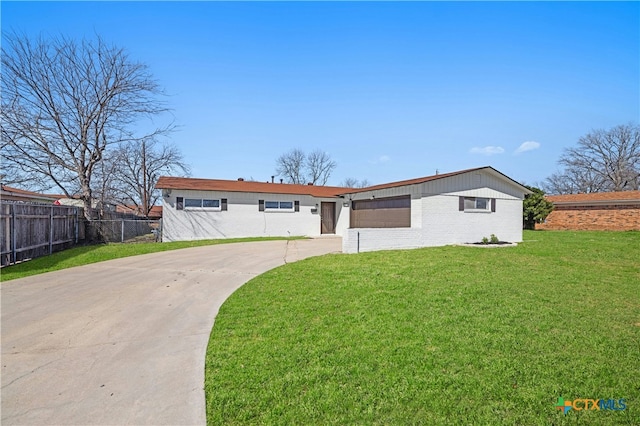 view of front facade with driveway, an attached garage, fence, a front yard, and brick siding