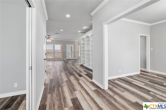 hallway featuring built in shelves, wood-type flooring, and crown molding