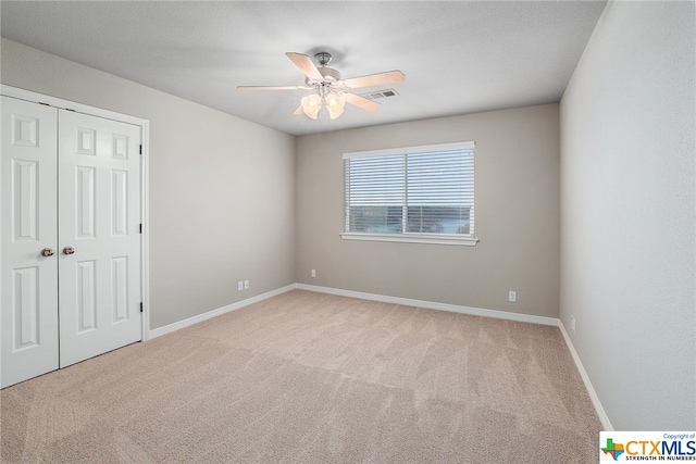 unfurnished room with light colored carpet and ceiling fan