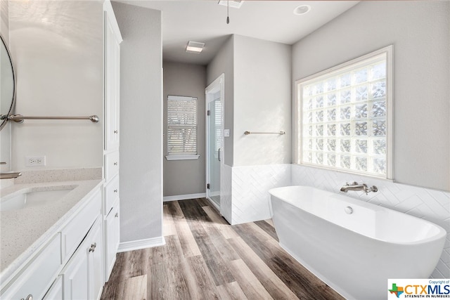 bathroom featuring vanity, wood-type flooring, and a washtub