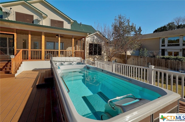 view of swimming pool featuring an outdoor hot tub and a wooden deck