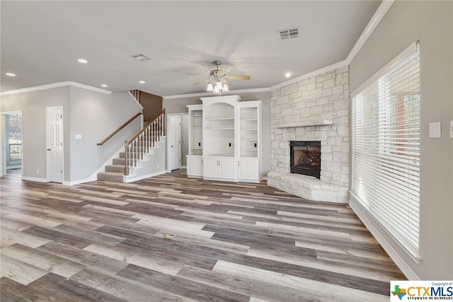 unfurnished living room featuring ornamental molding, ceiling fan, hardwood / wood-style flooring, and a healthy amount of sunlight