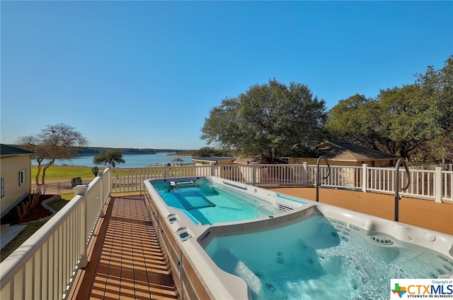 view of swimming pool with a hot tub and a deck with water view