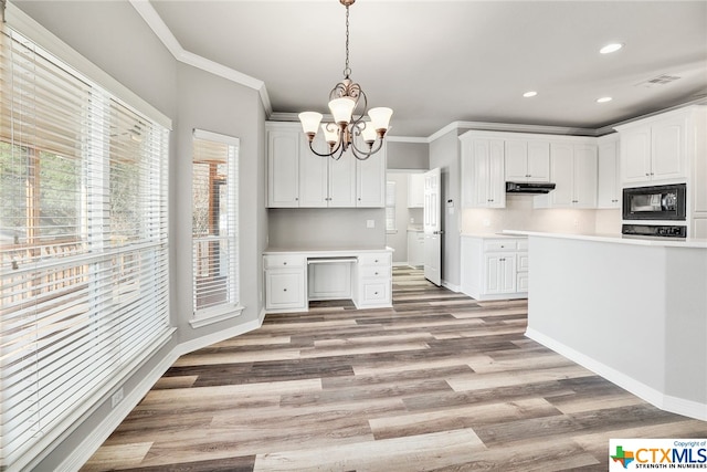 kitchen featuring ornamental molding, light hardwood / wood-style flooring, white cabinets, black microwave, and pendant lighting