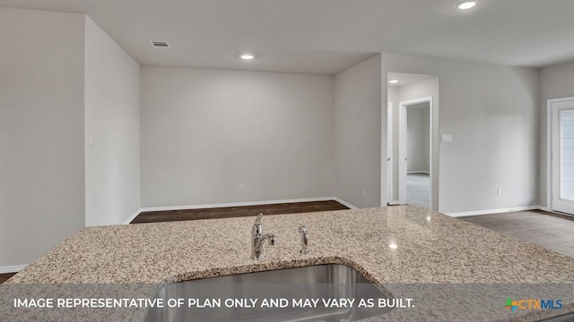 kitchen with light stone counters and sink